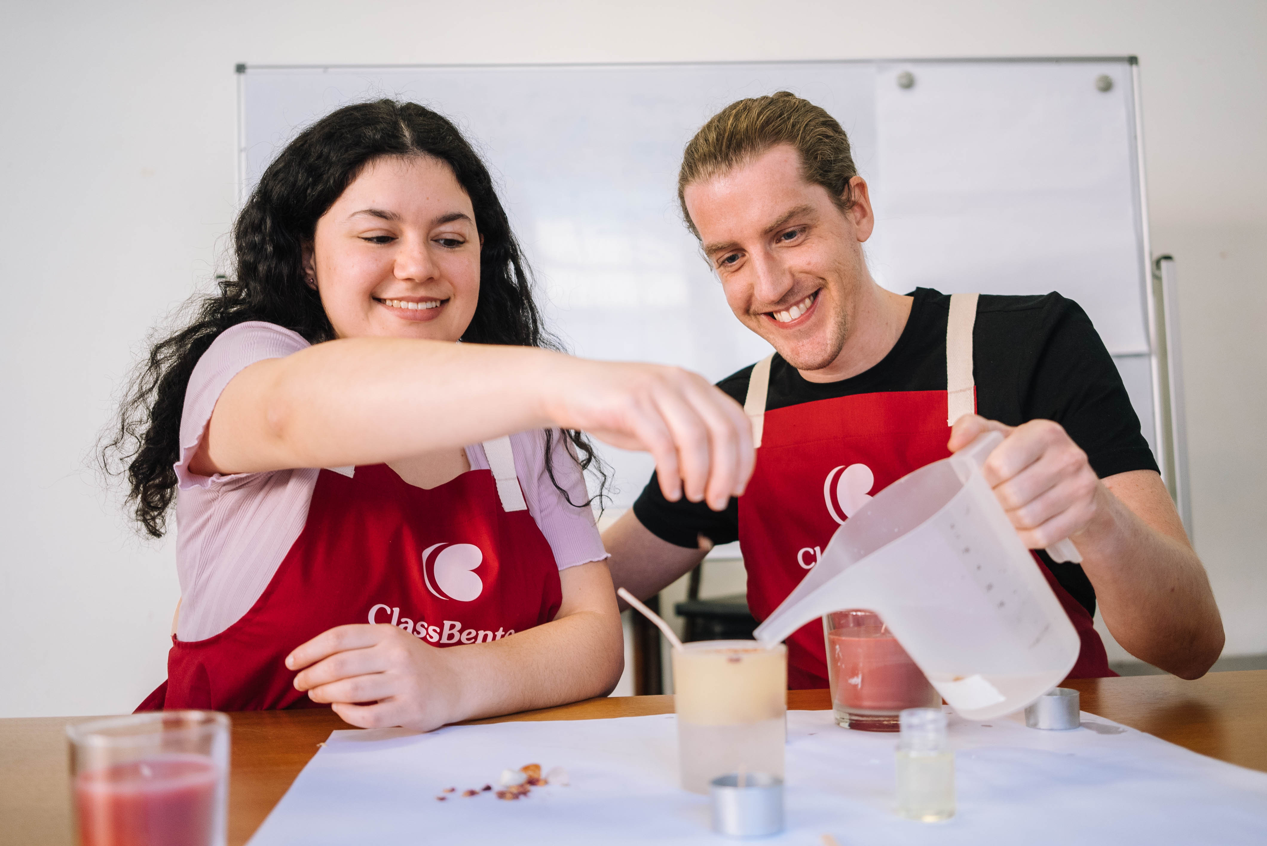 Two people making soy candles at a Christmas craft class